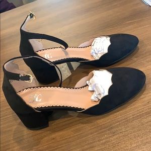 Black suede scalloped pumps.